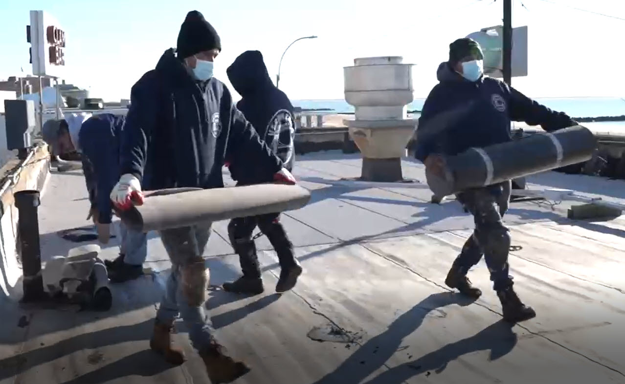 Verrazano crew carrying roofing material together